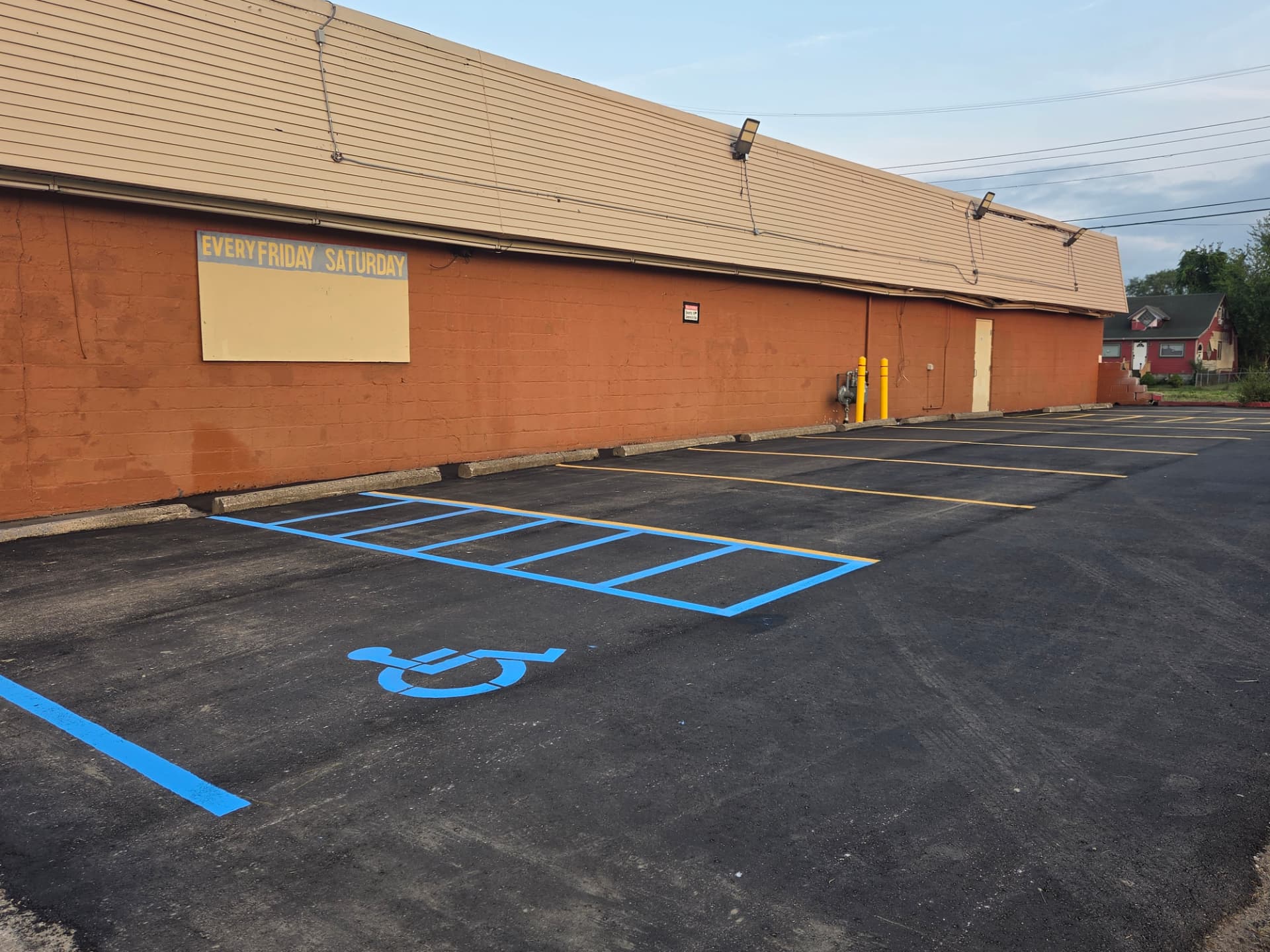 Blue ADA accessible stalls and handicap symbol striping next to a yellow crosshatch no-parking zone